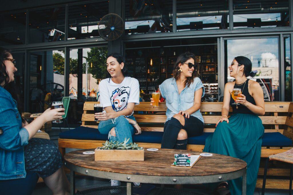 Drei Frauen sitzen außerhalb eines Restaurants