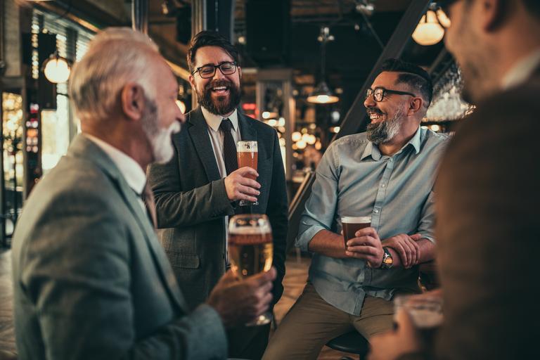 Ein Team von Kollegen, die sich an der Bar treffen und Bier trinken